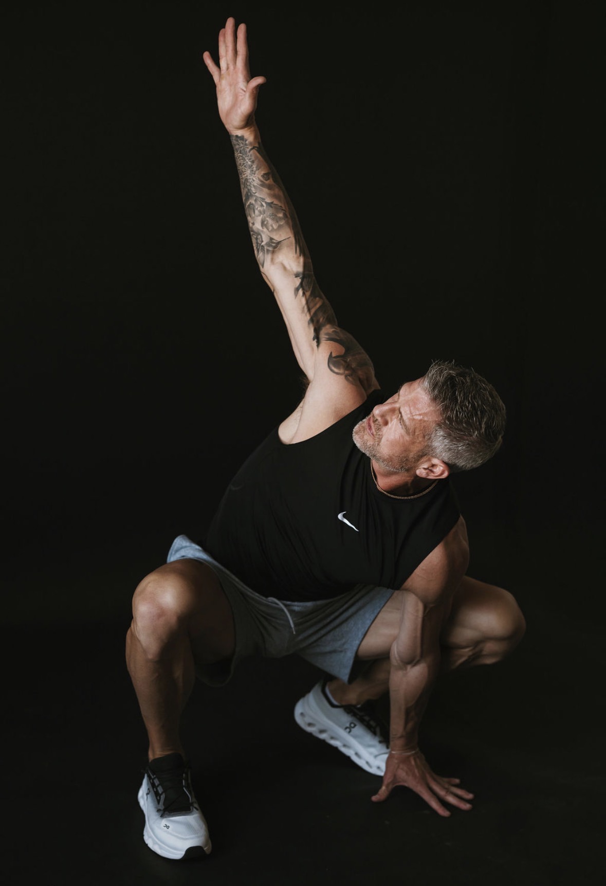 Brandon Burke moving through a low reaching pose in the studio